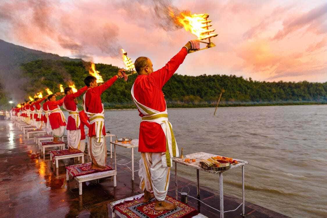 Evening Ganga Aarti ceremony at Triveni Ghat with priests performing rituals on Maa Ganga river